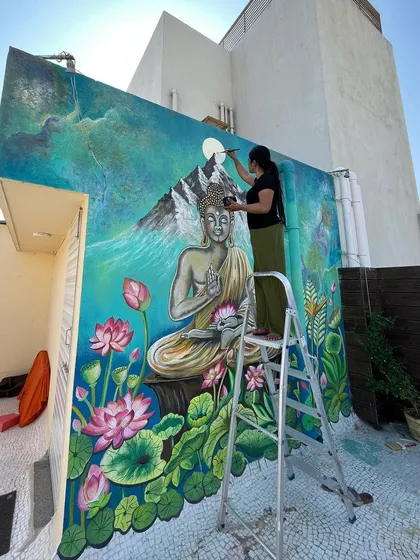 Adding the final touches to the moon in the Buddha mural.