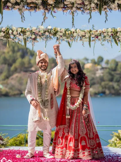 A joyous moment from a lakeside wedding. The bride's hair, styled in soft waves, moves beautifully and looks natural in the outdoor setting.