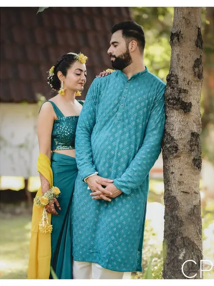 A calm portrait of the couple amidst their Haldi festivities, taking a moment for themselves by a tree.