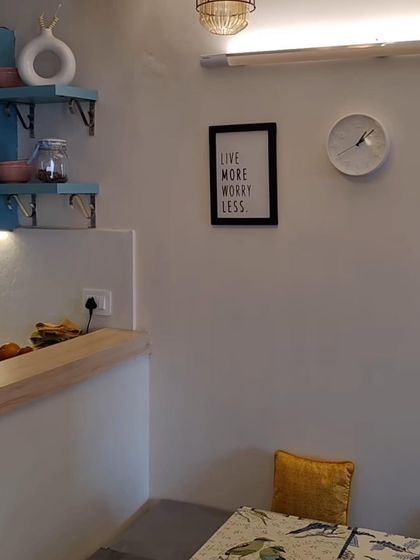 A cozy corner in our Lotus Boulevard project. The small details like the wall clock, art print, and open shelves make the space feel personal and lived-in.