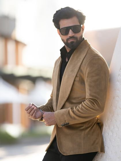 A close-up of the mustard velvet blazer, highlighting the soft sheen of the fabric and the wide, elegant lapel.