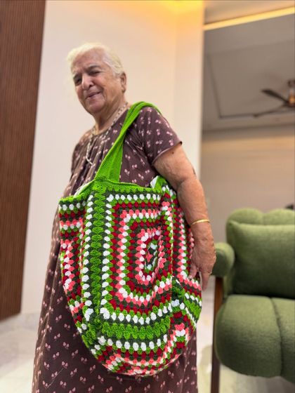This oversized granny square tote is a real statement piece. The vibrant green, pink, and white design is perfect for making a bold style statement.