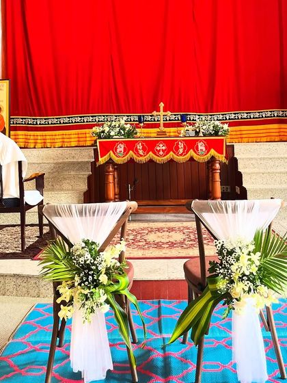 The couple's chairs are an important detail in a church wedding. I decorated these with white drapes, palm leaves, and small floral bouquets for an elegant and special touch.