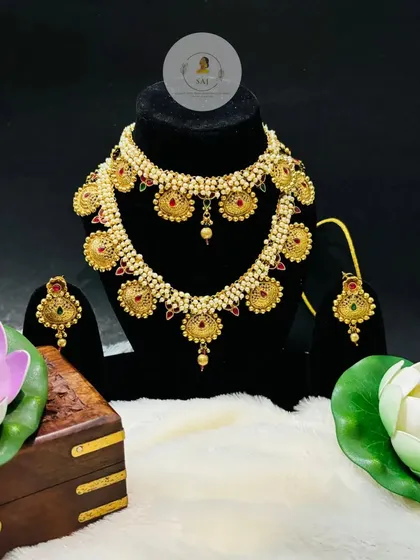 A stunning Maharashtrian 'Putli Haar' set, featuring coin-like pendants on a pearl-stringed necklace. This set includes a matching choker and earrings for a complete look.