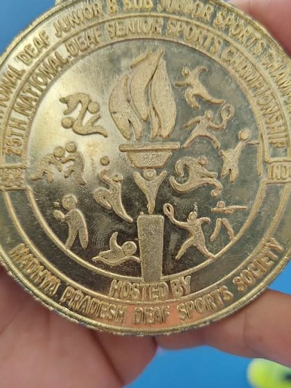 A close-up of the gold medal from the National Deaf Sports Championship. We are proud to have coached a national champion, proving that tennis is a sport for everyone.