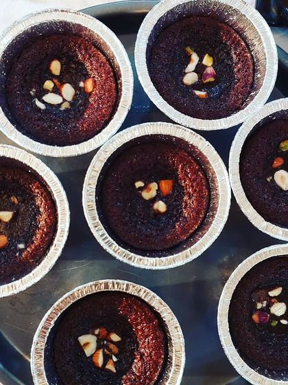 Individual chocolate lava cakes topped with nuts.