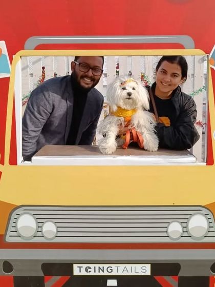 Another happy couple with their adorable white dog enjoying the custom photo booth at the Doggo Christmas Carnival.