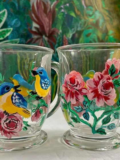 These elegant glass mugs feature birds nestled among pink roses, a classic and romantic design.