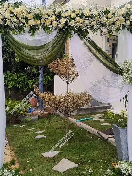 A beautiful outdoor arch with white roses and green and white fabric, perfect for weddings, engagements, or garden parties.