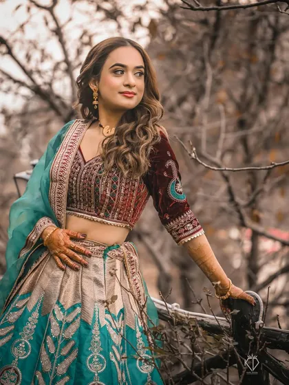 A three-quarter portrait of the bride, her vibrant outfit contrasting beautifully with the rustic, woody background.