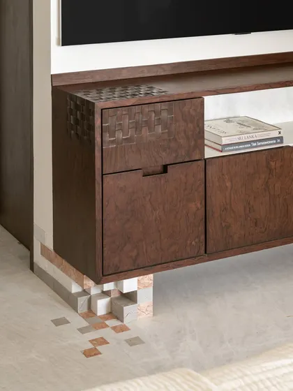We love adding playful details where you least expect them. This burlwood media unit is grounded by pixel-like marble blocks, a detail that connects it to the geometric marble inlay on the floor, creating a cohesive design story.