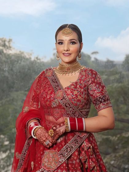 A classic red lehenga paired with soft, glowing makeup. This look is perfect for the bride who wants to look traditional yet feel modern and comfortable on her big day.