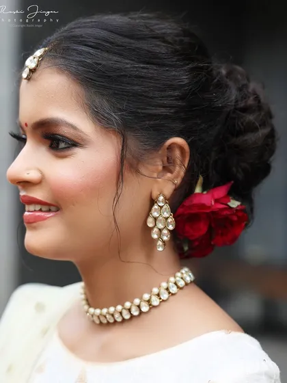 A close-up profile shot highlighting the clean lines of the updo and the flawless skin finish.