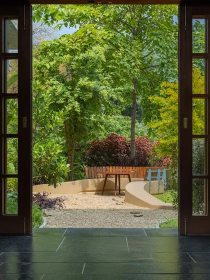 **Playfold Landscape, Ahmedabad:** We believe in blurring the lines between inside and out. This view from the home into the 'Playfold' courtyard shows how a once-underutilized lawn was transformed into a living landscape, seamlessly extending the home's daily rhythm into the outdoors.