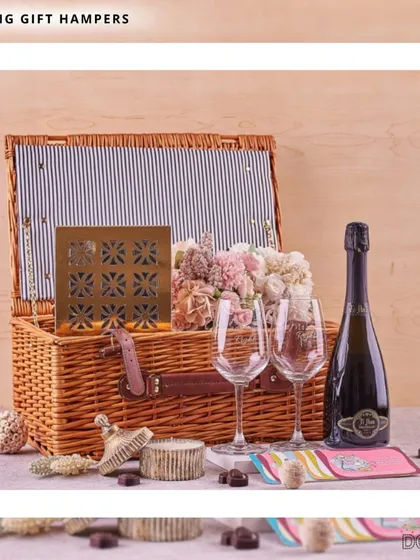 I designed this elegant wedding hamper as the perfect romantic gesture for newlyweds. It includes a classic wicker picnic basket, sparkling wine, engraved glasses, and a selection of fine chocolates and flowers, setting the scene for a memorable celebration.