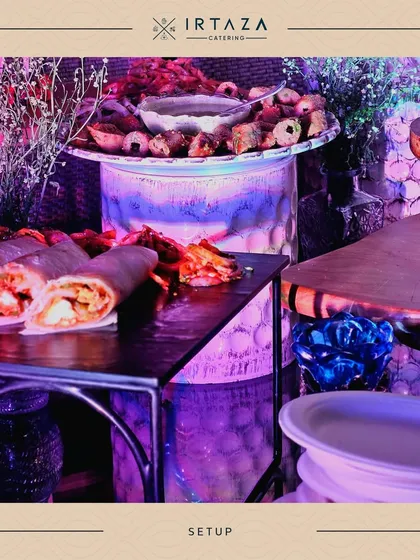 A creative and colorful setup for a casual event. The illuminated, multi-colored base for the serving tables adds a fun and unique touch, perfect for a lively party atmosphere.