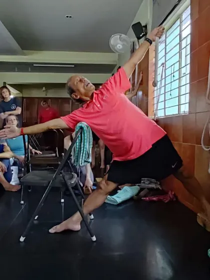 Here, I am demonstrating Utthita Trikonasana, or Triangle Pose, using a chair and ropes to help deepen the stretch and maintain correct alignment. This is a core principle of Iyengar yoga, where props assist in exploring the asana safely.