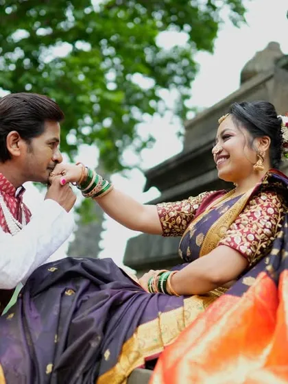A classic romantic gesture. The groom-to-be kisses his navri's hand as she sits gracefully, dressed in a beautiful traditional saree.