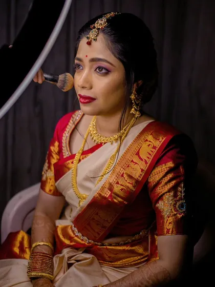Vasudha getting her makeup done for her Muhurtham. This shot shows the application process with professional lighting.