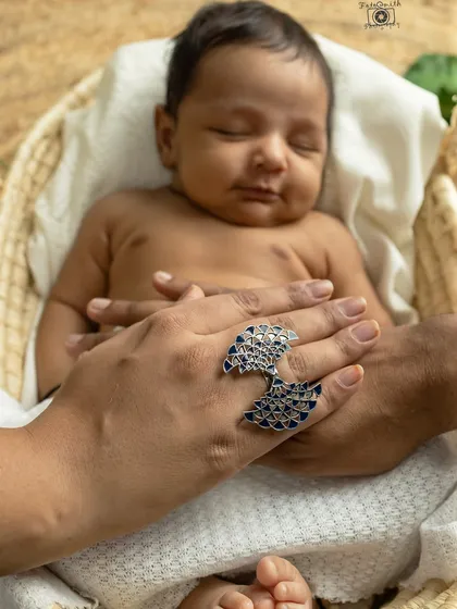 Parents' hands gently holding their baby's. The addition of the mother's beautiful ring adds a personal and artistic touch to this detail shot.