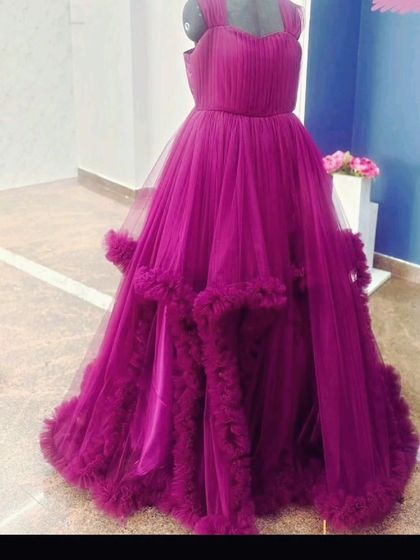 This wine-colored ball gown features a simple bodice and a dramatic, ruffled tulle skirt. It's a beautiful rental piece for a pre-wedding shoot or maternity session.