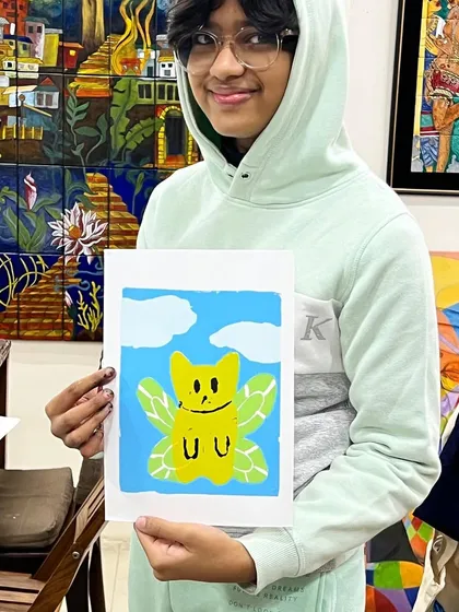 This young artist is all smiles with his whimsical, winged character print made during our silkscreen class.