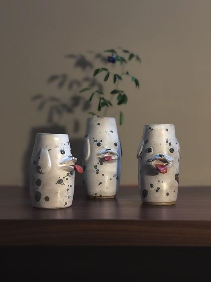 A trio of dog-faced vases, each with its own goofy expression. These are great for holding single stems or just for adding a bit of fun to your decor.