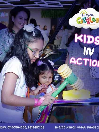 Kids in action! A young girl gets help from her older sister to play one of our hammer arcade games. It's a great way for siblings to team up and have fun.