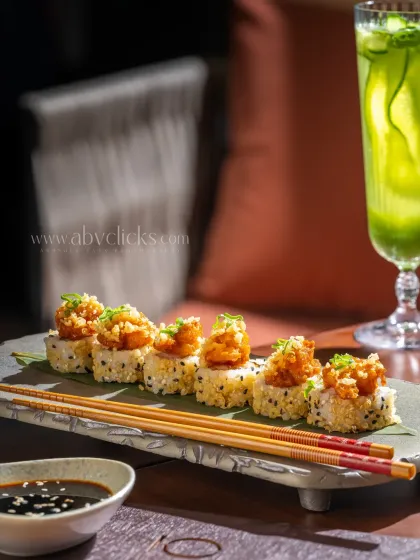 A plate of delicious looking sushi rolls at Camo, Noida, captured in a relaxed cafe setting.
