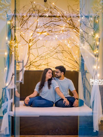 Matching outfits and a magical backdrop make for a perfect pre-wedding photo in our fairy-lit indoor bed setup.