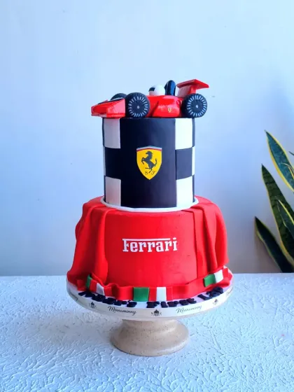 A full view of the two-tiered Ferrari cake, showing the draped fondant and checkered tier.