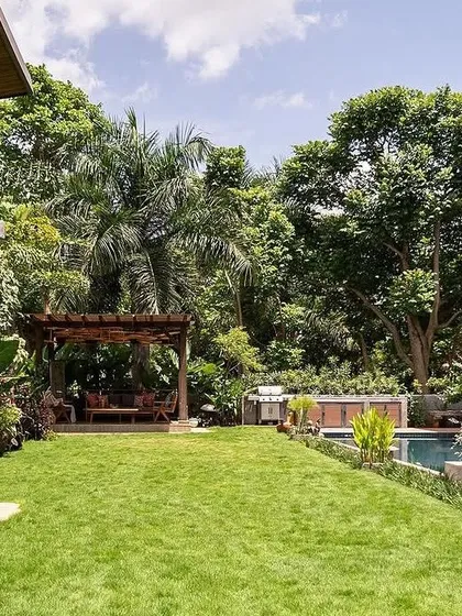 For this expansive villa at Embassy Boulevard, I designed a tropical paradise featuring a vast lawn, a serene poolside, and a custom gazebo, creating a seamless connection between the home and its natural surroundings.