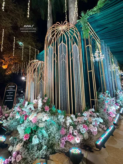 A side view of the grand entrance, showing the layers of gold structures, green drapes, and floral beds.