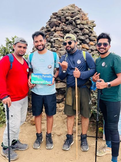 Four friends posing at the peak, proud of their accomplishment. This is what trekking with friends is all about.