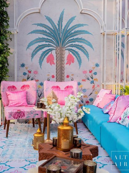 Hand-painted murals featuring botanical motifs were a key element of the 'Botanical Marrakesh' design. The vibrant pink and turquoise furniture popped against the delicate artwork, creating a cheerful and artistic atmosphere.