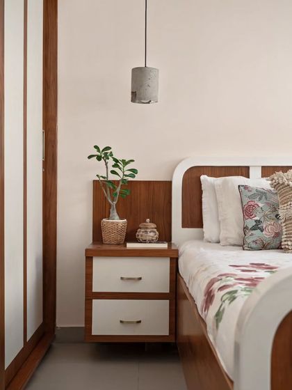 The transformed master bedroom, now more spacious after enclosing the balcony. The room features a custom king-size bed and storage in Duco and Teak veneer, with concrete pendant lights adding a raw touch.