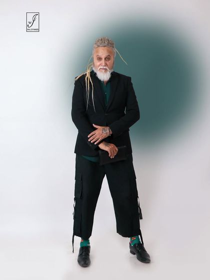 A modern, edgy look featuring a model with dreadlocks in a tailored blazer and cargo pants.