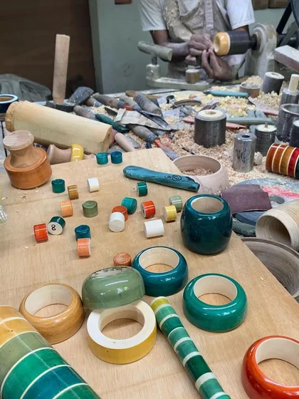 The artisan's workshop is filled with colorful wooden components in various stages of completion. This scene captures the vibrant energy and meticulous labor that goes into creating each piece for our custom installations.