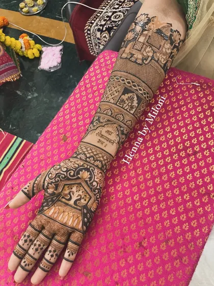 A full-arm bridal design with a Sanskrit shloka, 'Sada Saubhagyavati Bhava', a blessing for the bride.