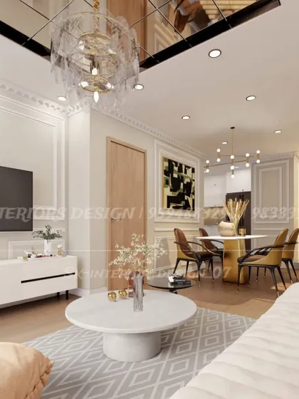 A bright and airy living room with classic wall molding and a reflective ceiling panel. The design combines a modern TV console with elegant furniture for a transitional look.