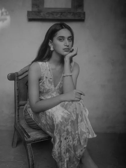 A seated portrait for a PhotoVogue feature, shot on film to achieve a timeless and classic look. The use of natural light and shadow creates depth and mood, ideal for editorial photography.