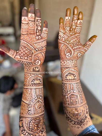 A full-coverage bridal design with classic motifs like peacocks, elephants, and a kalash, all tied together with intricate line and dot work.