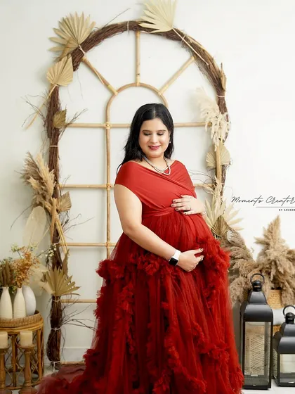 A quiet moment of reflection. The mom-to-be cradles her bump in the warm and earthy boho setup, creating a peaceful and beautiful portrait.