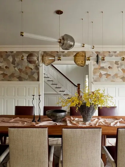 A horizontal Luna Kaleido fixture in a classic dining room. The modern lighting provides a beautiful contrast to the traditional wainscoting and wallpaper.