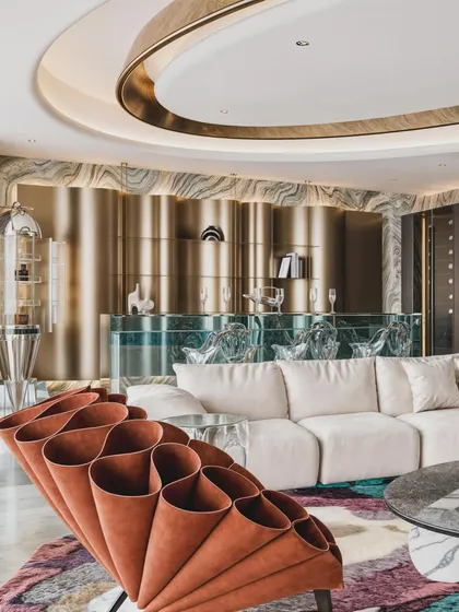 A striking view featuring a sculptural orange armchair against a backdrop of a fluted brass bar and onyx marble wall. This render is a testament to visualizing bold, artistic interiors.