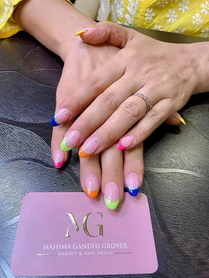 A playful and colorful twist on the classic French manicure. Each nail features a different neon color tip, including blue, green, orange, and pink, for a fun and summery vibe.