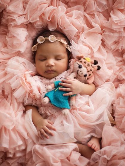 Back to sleep, cuddling a tiny friend. Adding a small stuffed animal can make the photo even sweeter and more personal, especially if it's a special toy.