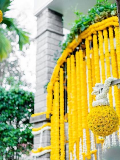 A detailed shot of the Haldi decor, focusing on the beautiful marigold and tuberose hangings. These traditional floral elements add fragrance and a classic touch to the celebration.