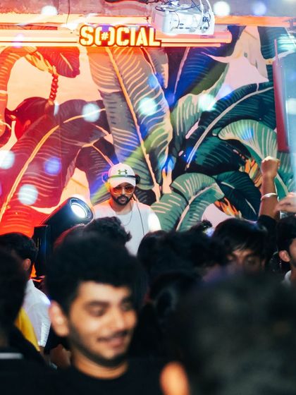 A view from the crowd, looking up at me in the DJ booth. I'm always visible, always part of the party.