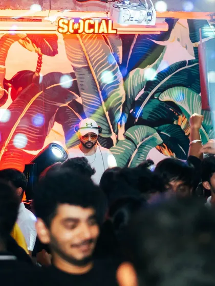 A view from the crowd, looking up at me in the DJ booth. I'm always visible, always part of the party.